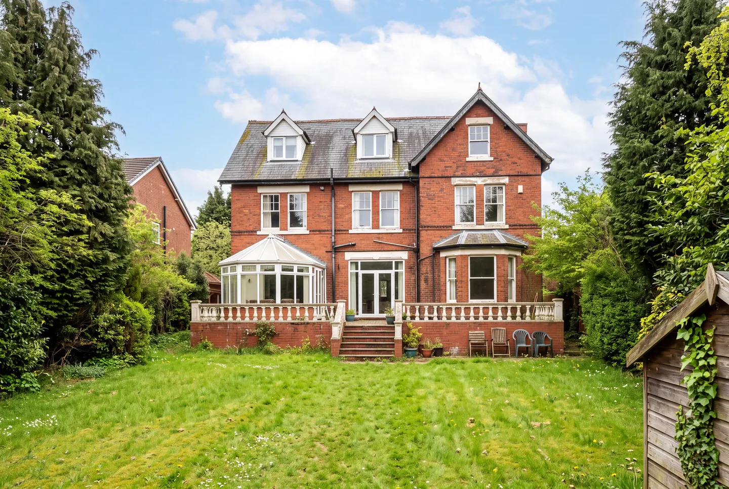 Illustration of a large Edwardian red-brick house from its rear garden