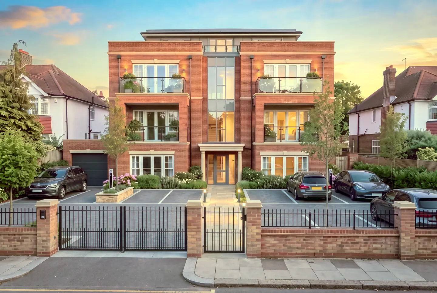 Proposed concept: a red-brick apartment building with stacked balconies, a glazed stair core and a gated parking forecourt in warm evening light